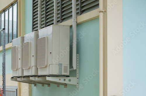 Air conditioner installed on the wall of the building, side angle photo