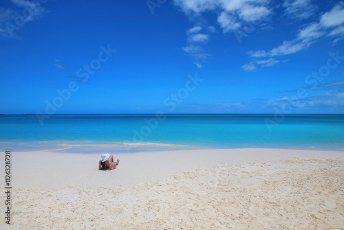 Woman relaxing on Fayaoue beach on the coast of Ouvea lagoon, Mouli and Ouvea Islands, New Caledonia photo