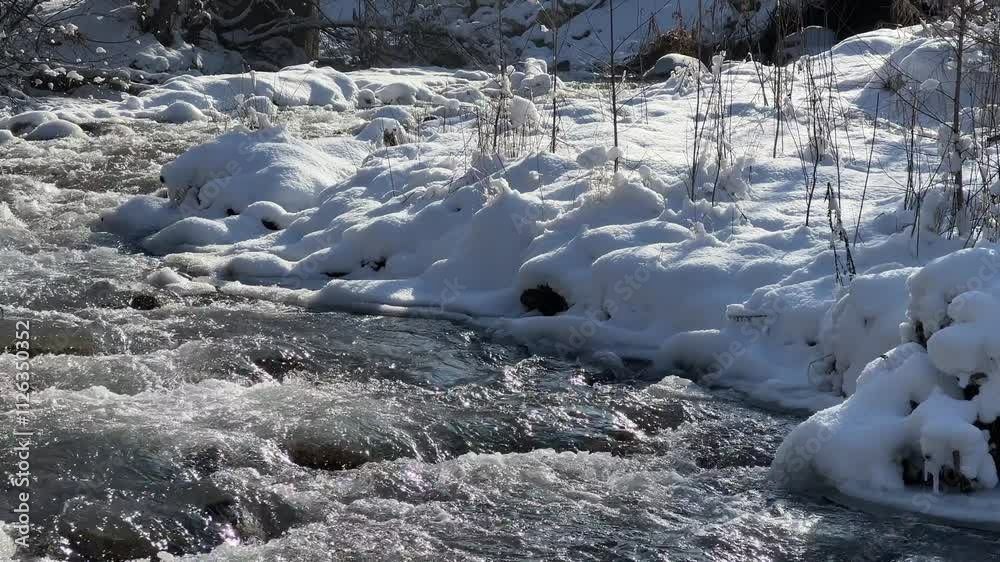 A river in a mountainous area in winter. A stormy stream. A river in a mountainous area in winter. A stormy stream.
