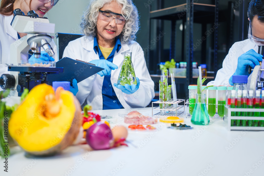 A male scientist and two women conduct plant research in a laboratory. microscopes, petri dishes,test tubes to analyze genetically modified plants, food, meat, eggs,vegetables for nutritional value A male scientist and two women conduct plant research in a laboratory. microscopes, petri dishes,test tubes to analyze genetically modified plants, food, meat, eggs,vegetables for nutritional value
