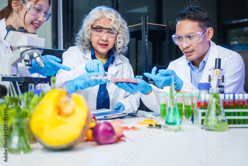 A male scientist and two women conduct plant research in a laboratory. microscopes, petri dishes,test tubes to analyze genetically modified plants, food, meat, eggs,vegetables for nutritional value