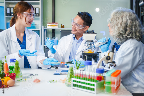 A male scientist and two women conduct plant research in a laboratory. microscopes, petri dishes,test tubes to analyze genetically modified plants, food, meat, eggs,vegetables for nutritional value