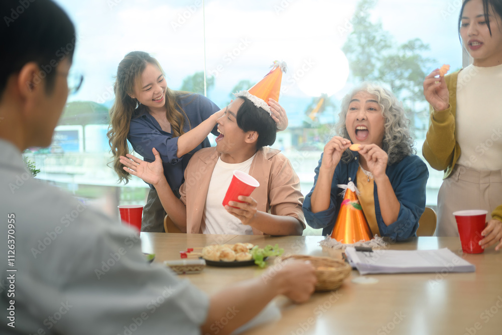 Obraz premium Group of cheerful coworkers enjoying at the office birthday party