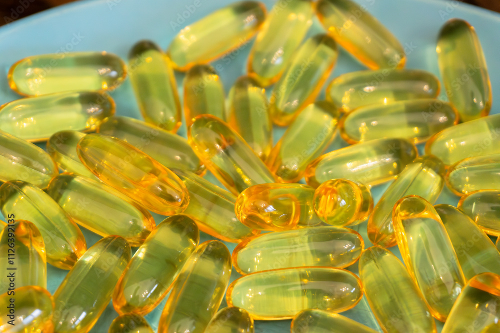 Soft gel capsules arranged on a blue plate in a well-lit setting