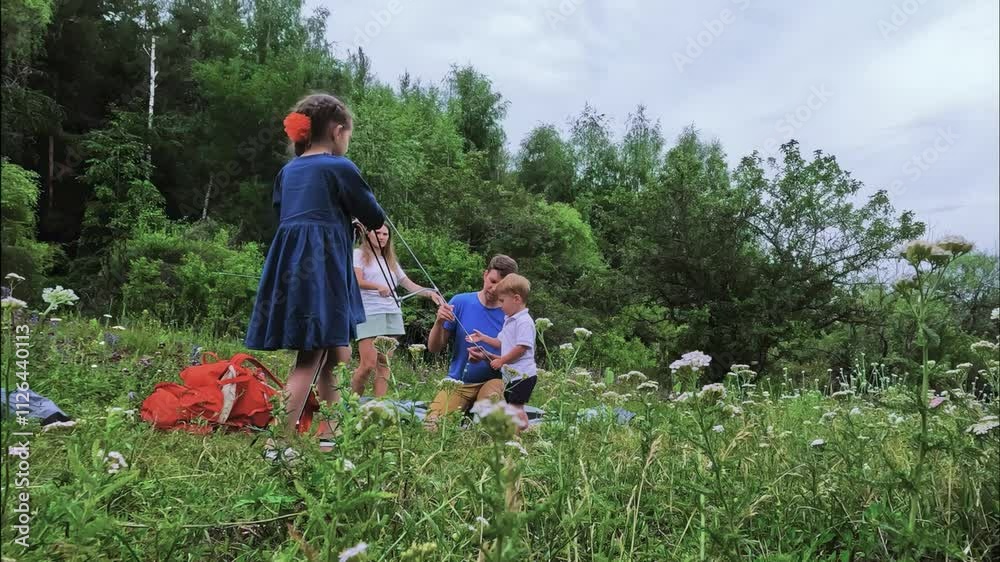 A joyful family picnic unfolds under the sun, with children happily enjoying their time in a green meadow A joyful family picnic unfolds under the sun, with children happily enjoying their time in a green meadow