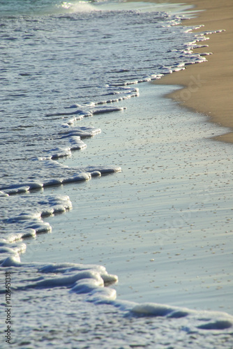 Close-up of surf on sandy beach photo