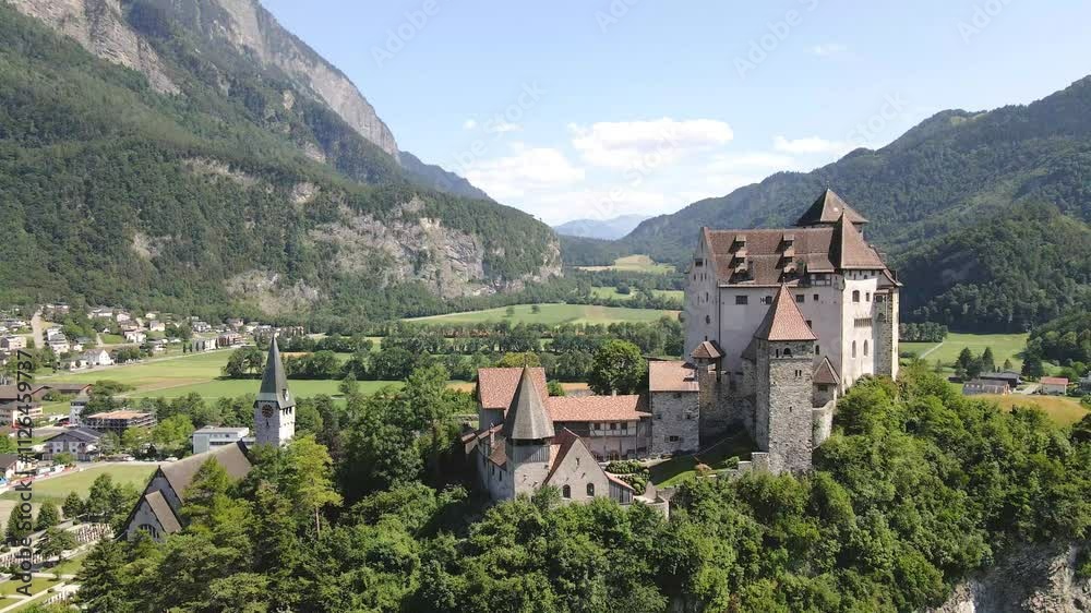 Gutenberg castle in Burg Gutenburg overlooking the town of Balzers in Liechtenstein, surrounded by mountains and greenery on a clear sunny day, drone pulling out shot Gutenberg castle in Burg Gutenburg overlooking the town of Balzers in Liechtenstein, surrounded by mountains and greenery on a clear sunny day, drone pulling out shot