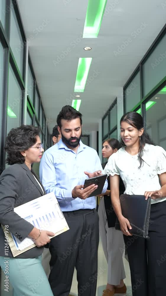 Group of young indian corporate businesspeople holding reports or documents discussing in the office. Teamwork and workspace concept. Vertical video. Group of young indian corporate businesspeople holding reports or documents discussing in the office. Teamwork and workspace concept. Vertical video.
