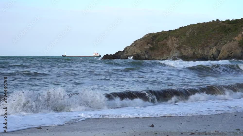 Rocky beach with crashing waves and lush green cliffs Rocky beach with crashing waves and lush green cliffs
