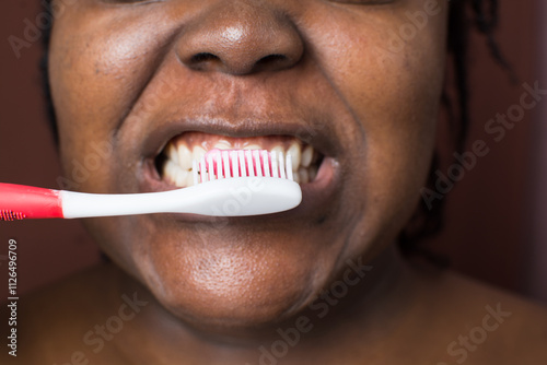 Brown skin woman brushing her teeth, woman practicing oral dental hygiene, using a tooth brush to clean teath photo