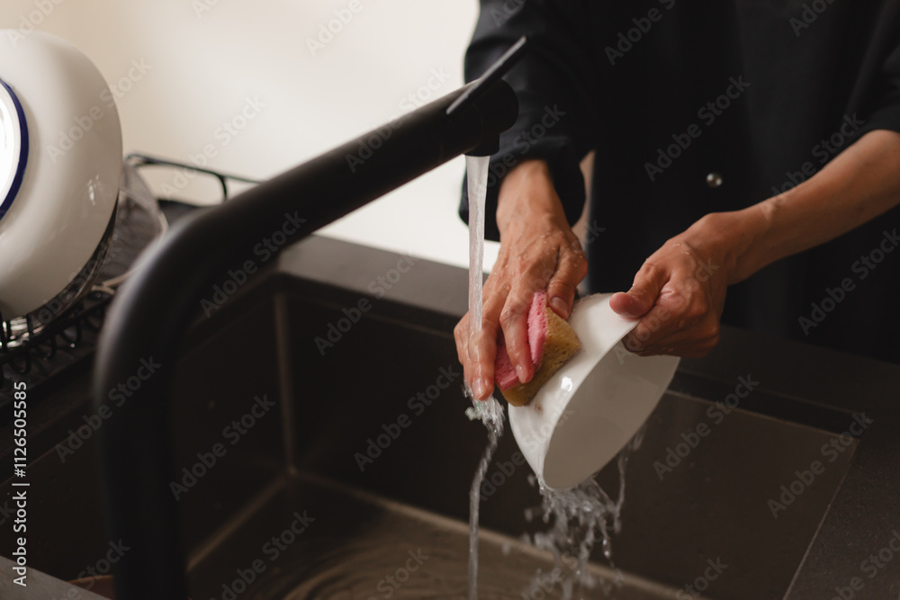 Close up of woman housewife is washing the dishes plated at home kitchen by using wash sponge and dishwashing. Close up of woman housewife is washing the dishes plated at home kitchen by using wash sponge and dishwashing.