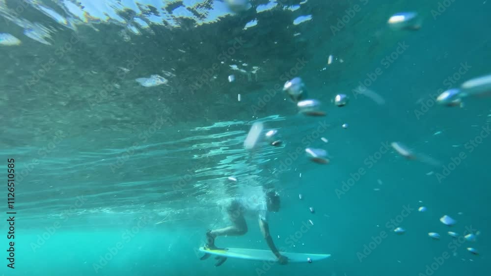 Young male surfer making duck dive in the ocean, Indonesia Young male surfer making duck dive in the ocean, Indonesia