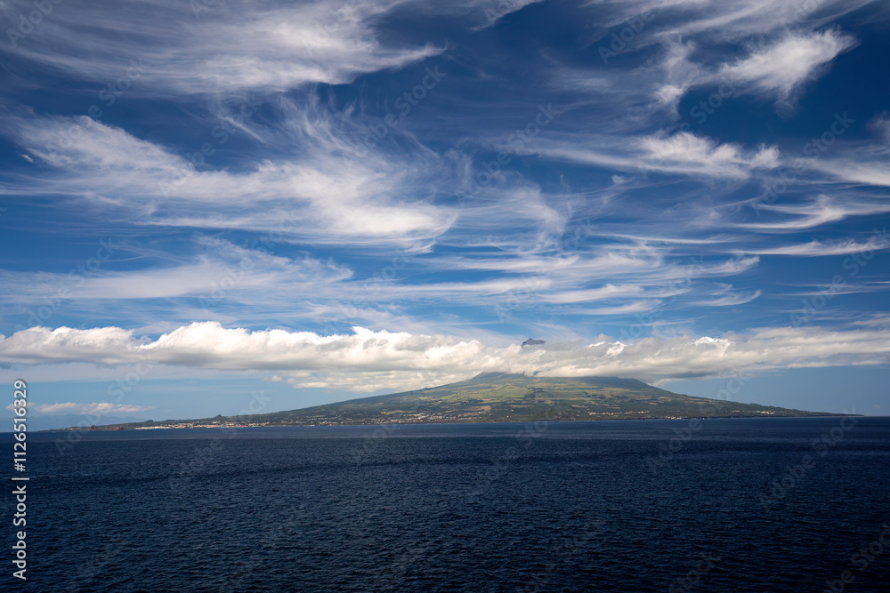 The highest cloud-covered peak of Porugalia on the Azores island of Pico in the Atlantic Ocean. View from the island Faial The highest cloud-covered peak of Porugalia on the Azores island of Pico in the Atlantic Ocean. View from the island Faial