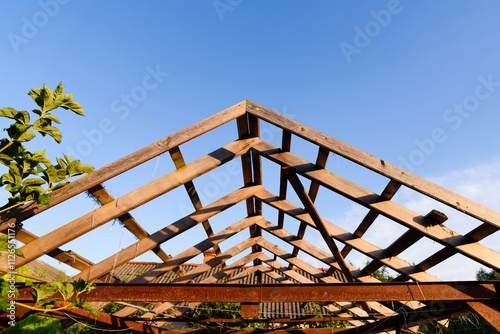 Wooden structure roof frame carport roof frame against blue sky, process of building a garage, outbuilding, house. Construction works. Installation of roofs