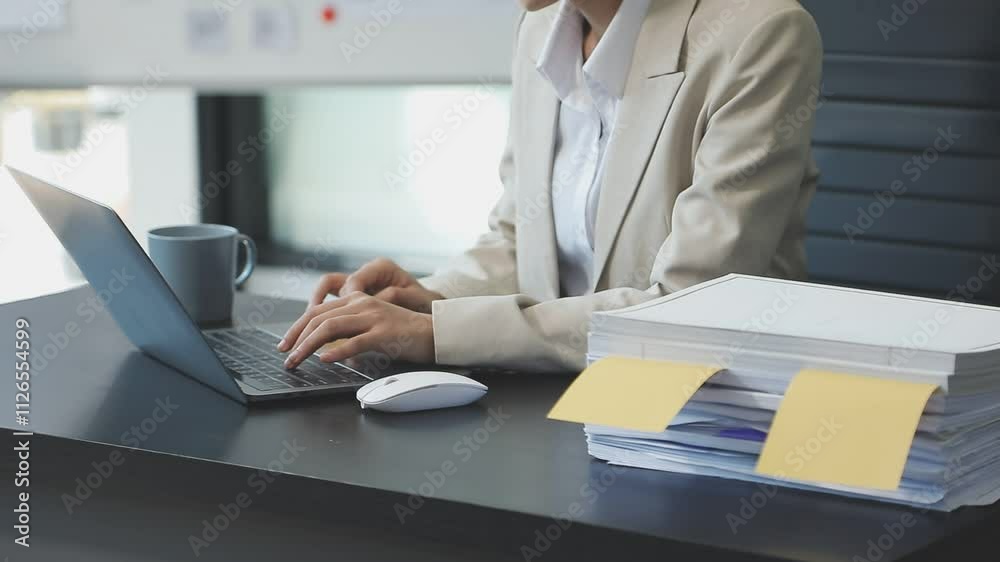 Asian Businesswoman Using laptop computer and working at office with calculator document on desk, doing planning analyzing the financial report, business plan investment, finance analysis concept. Asian Businesswoman Using laptop computer and working at office with calculator document on desk, doing planning analyzing the financial report, business plan investment, finance analysis concept.