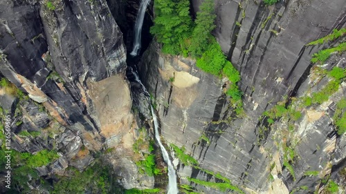 Aerial view of jogini waterfall surrounded by cedar forest in the himalayas in manali, himachal pradesh, India