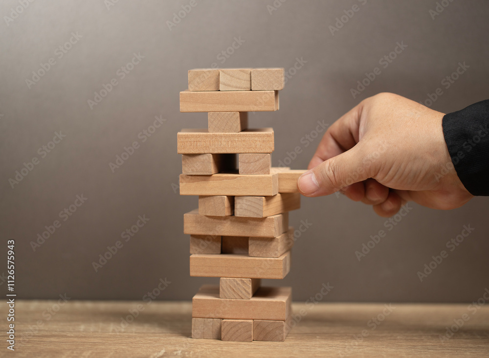 Planning, risk and strategy in business. man holds the model of business, made from wood blocks. Alternative risk concept, business plan and business strategy. Insurance concept. Company concept risk. Planning, risk and strategy in business. man holds the model of business, made from wood blocks. Alternative risk concept, business plan and business strategy. Insurance concept. Company concept risk.