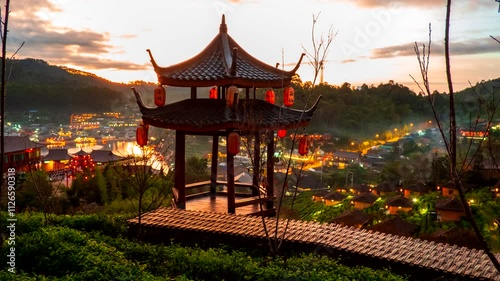 Time-lapse Night to day of the pavilion in tea plantations on the hills at Ban Ruk Thai, a Chinese Yunnan-style village amidst tea plantations. The Chinese words on the lanterns refer to place names.