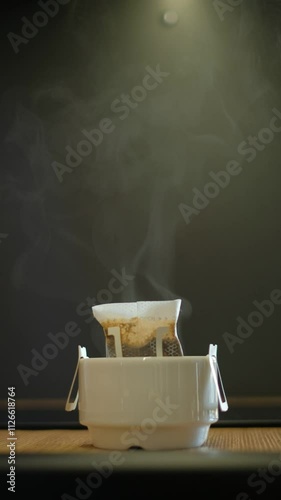 Steaming coffee drip bag in a cup, ready for brewing