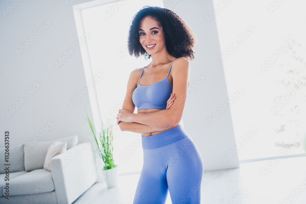 Confident young african american woman in blue activewear smiling in bright modern living room Confident young african american woman in blue activewear smiling in bright modern living room