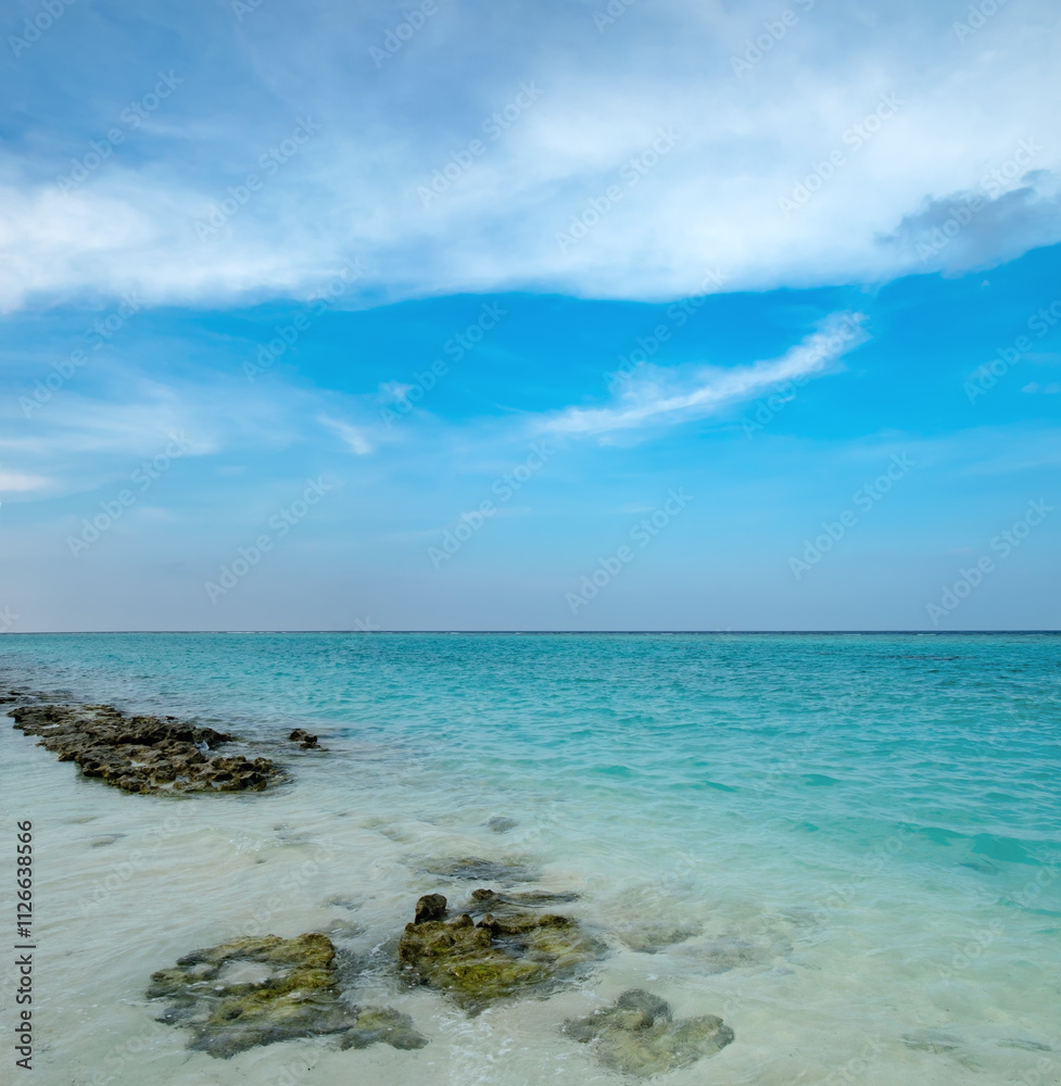Tropical beach paradise, turquoise waves and ripples texture to horizon, coast rocks in shallow water. Summer calm coastline landscape with exotic lagoon, vacation and tourism simple scenery Tropical beach paradise, turquoise waves and ripples texture to horizon, coast rocks in shallow water. Summer calm coastline landscape with exotic lagoon, vacation and tourism simple scenery