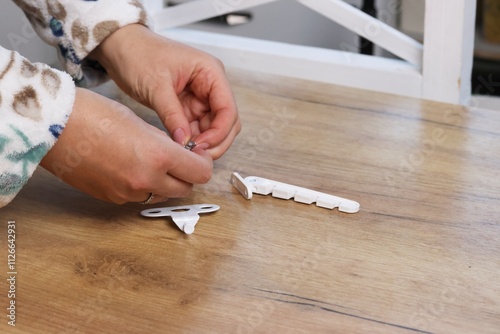 A woman is examining a window latch. Purchase review.