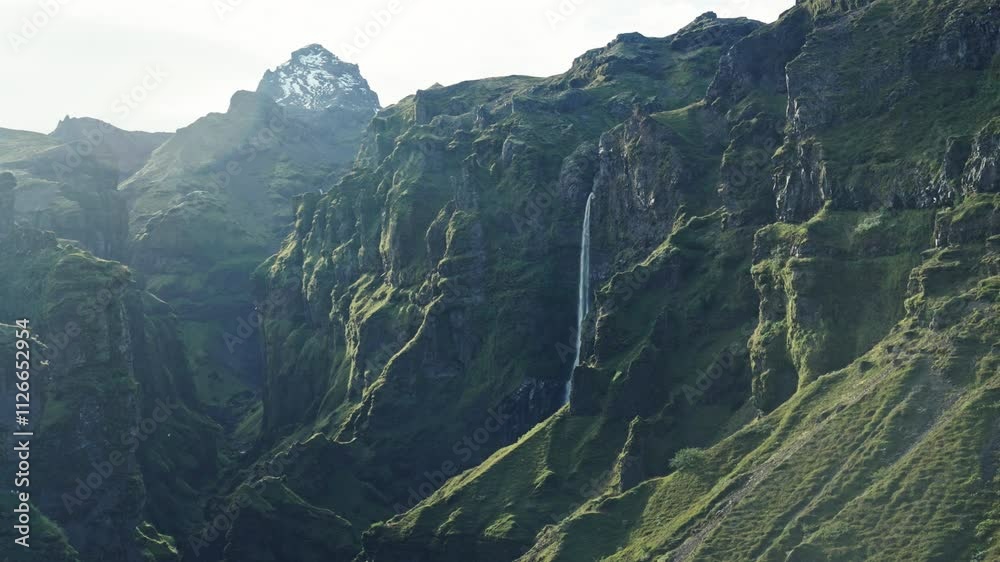 View of the green Mulagljufur canyon in Iceland with a breathtaking waterfall during summer View of the green Mulagljufur canyon in Iceland with a breathtaking waterfall during summer
