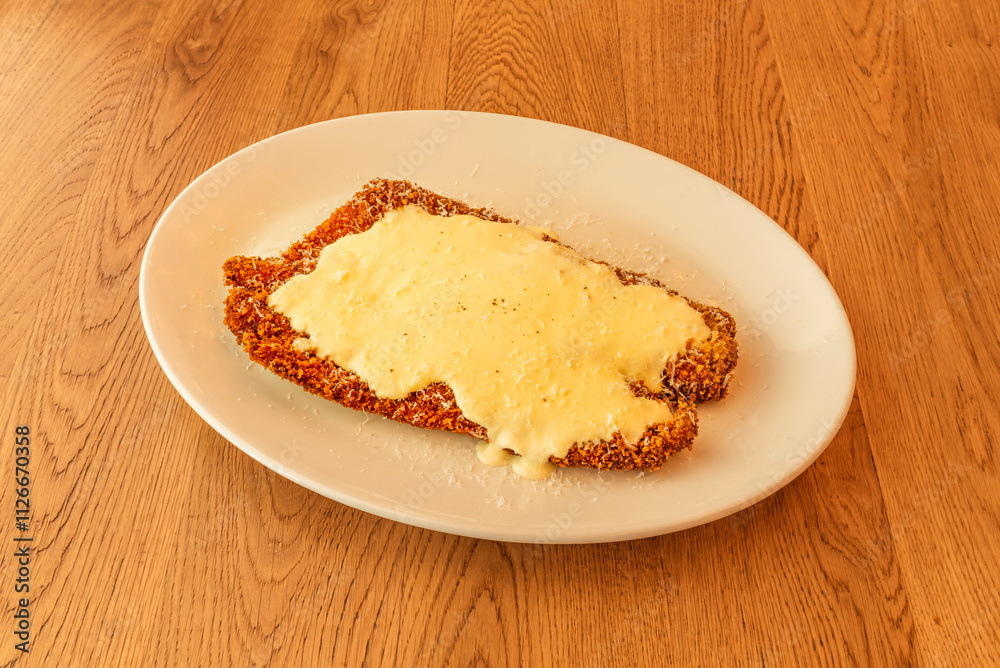 A large breaded steak with lots of sauce on top A large breaded steak with lots of sauce on top