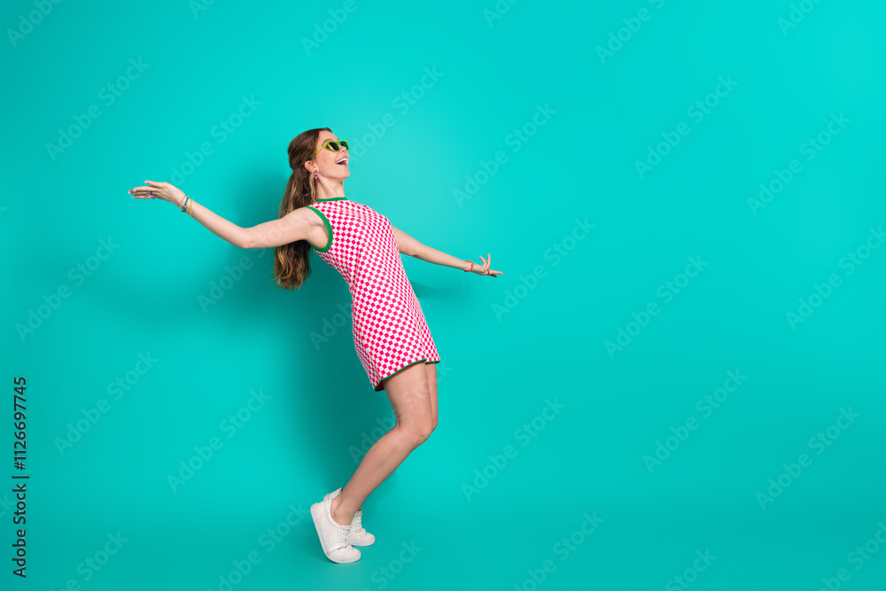 Full body photo of attractive teen woman tiptoes dancing dressed stylish checkered pink clothes isolated on cyan color background Full body photo of attractive teen woman tiptoes dancing dressed stylish checkered pink clothes isolated on cyan color background