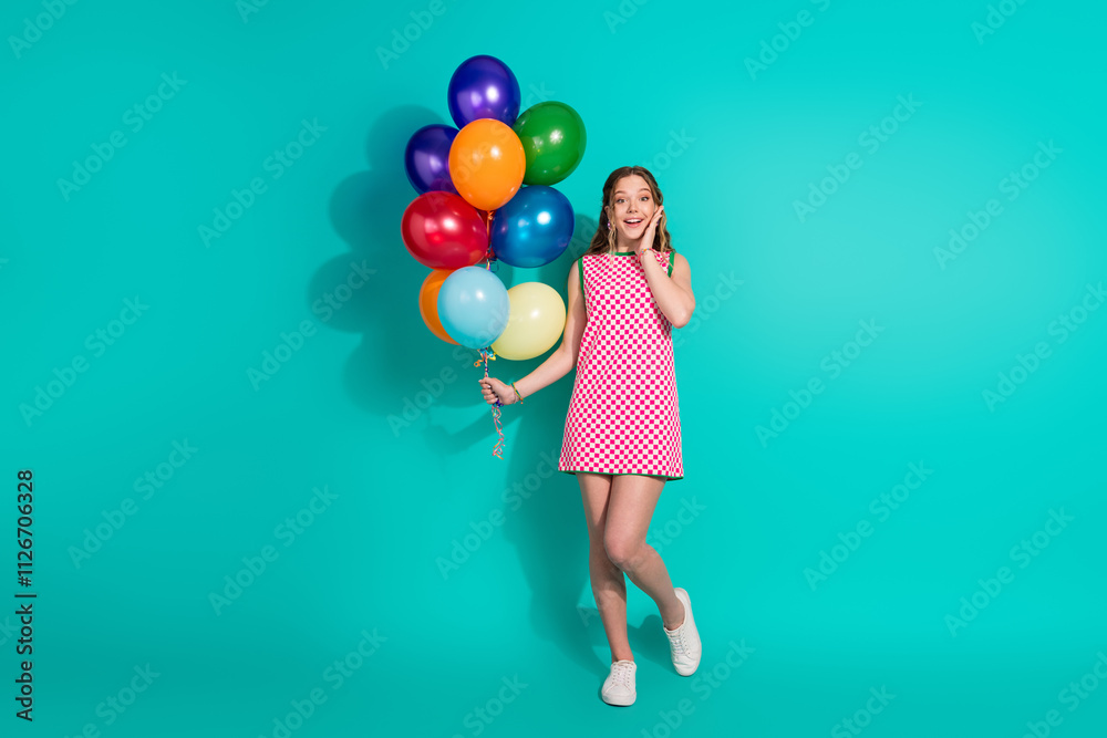 Full length photo of lovely teen lady hold air balloons amazed dressed stylish pink plaid garment isolated on cyan color background Full length photo of lovely teen lady hold air balloons amazed dressed stylish pink plaid garment isolated on cyan color background