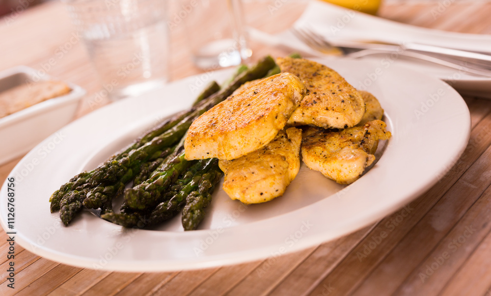 Cooked dish. Chicken nuggets with green asparagus on plate