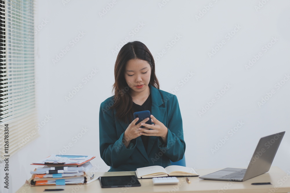 Young businesswoman using mobile phone in modern office. Young businesswoman using mobile phone in modern office.