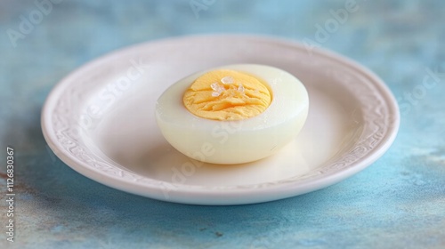Boiled egg on a white plate on a pastel blue background