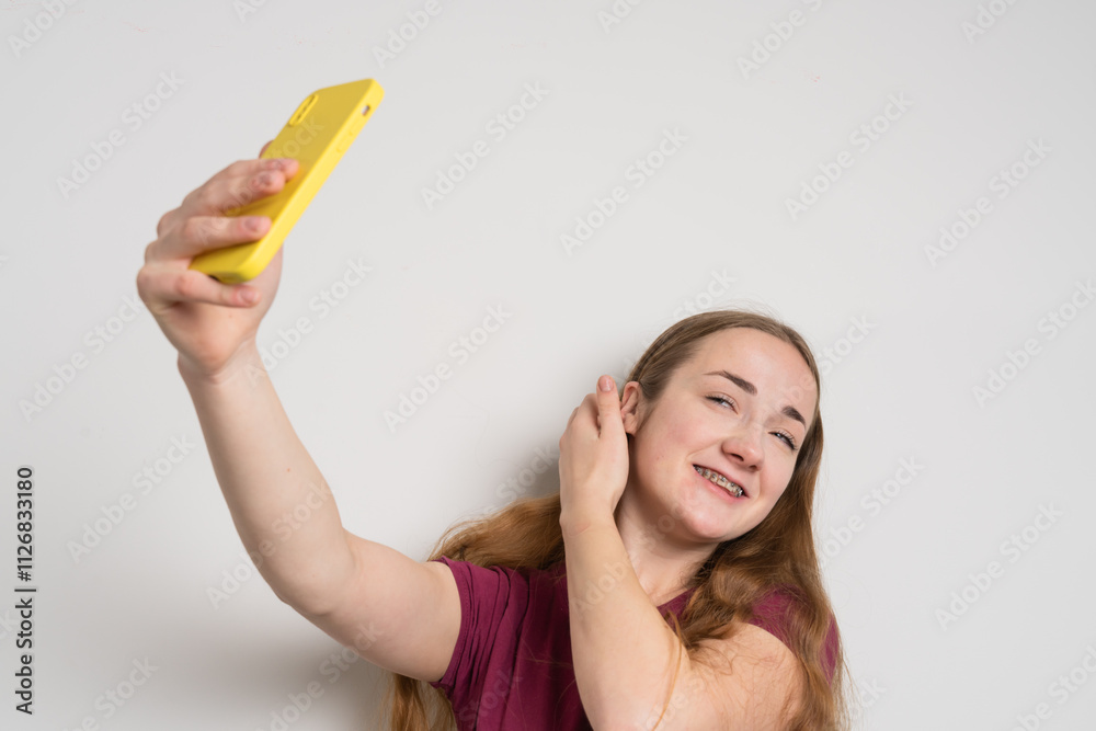 Young beautiful girl uses modern smartphone at home