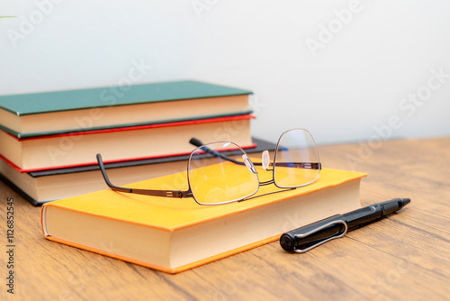 book eyeglass and pen on the table