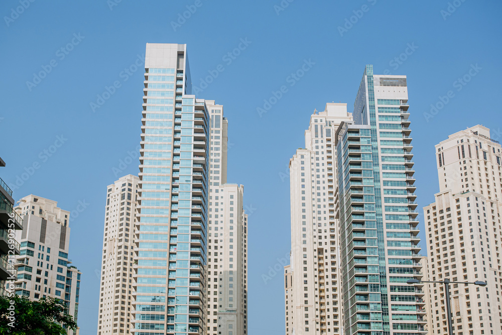 High-rise buildings with glass facade against blue sky. Business center. View from below High-rise buildings with glass facade against blue sky. Business center. View from below