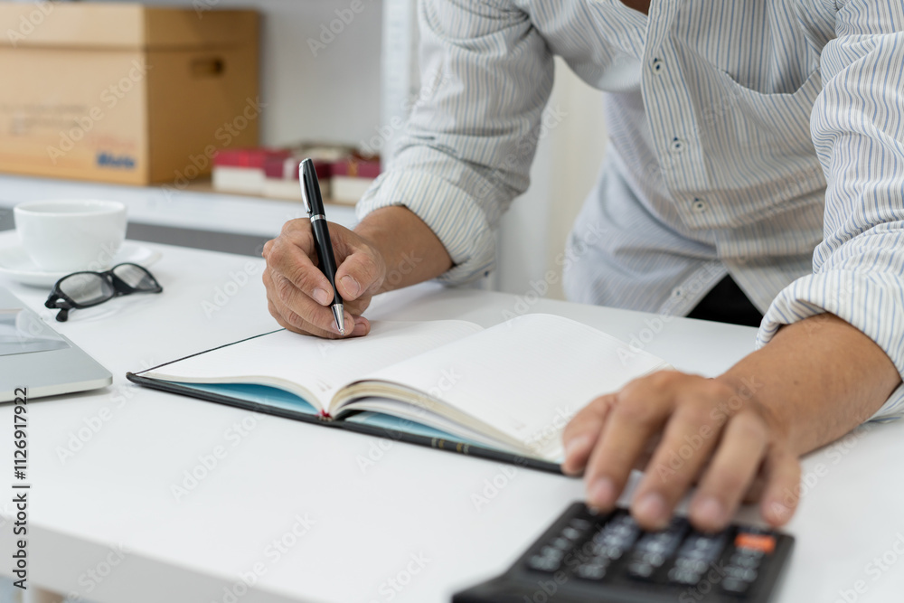 accountant reviews financial data using a calculator at desk in a busy office, ensuring accuracy in tax reporting and financial management. accountant reviews financial data using a calculator at desk in a busy office, ensuring accuracy in tax reporting and financial management.