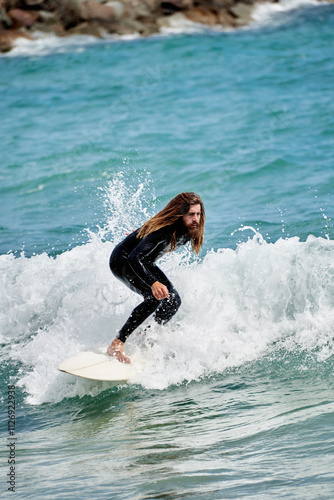 Surfboarder with long hair riding a wave