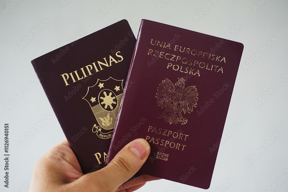 Paszport Rzeczpospolita Polska i paszport Filipiński. Dwa paszporty trzymane w dłoni. Paszport Rzeczpospolita Polska i paszport Filipiński. Dwa paszporty trzymane w dłoni.