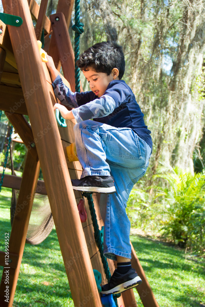 Close-up of a boy climbing a ladder in a park playground, USA Close-up of a boy climbing a ladder in a park playground, USA