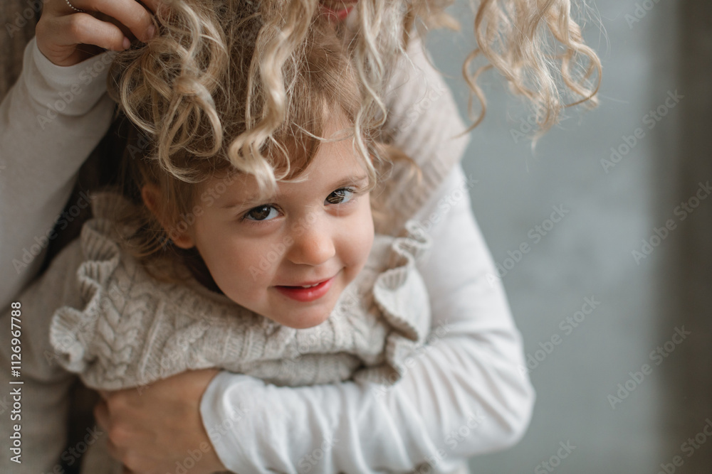 Close-up of a smiling young girl being hugged from behind by her mother Close-up of a smiling young girl being hugged from behind by her mother