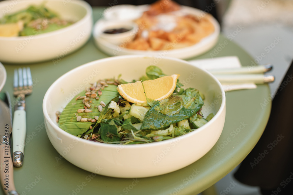 Close-up of an avocado, lettuce, cucumber and sunflower seed salad on a cafe table Close-up of an avocado, lettuce, cucumber and sunflower seed salad on a cafe table