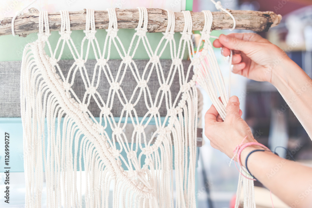 Close-up of a woman weaving a macrame craft product Close-up of a woman weaving a macrame craft product