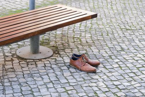 Wallpaper Mural Brown leather shoes on a cobblestone pavement next to a bench in an urban setting Torontodigital.ca