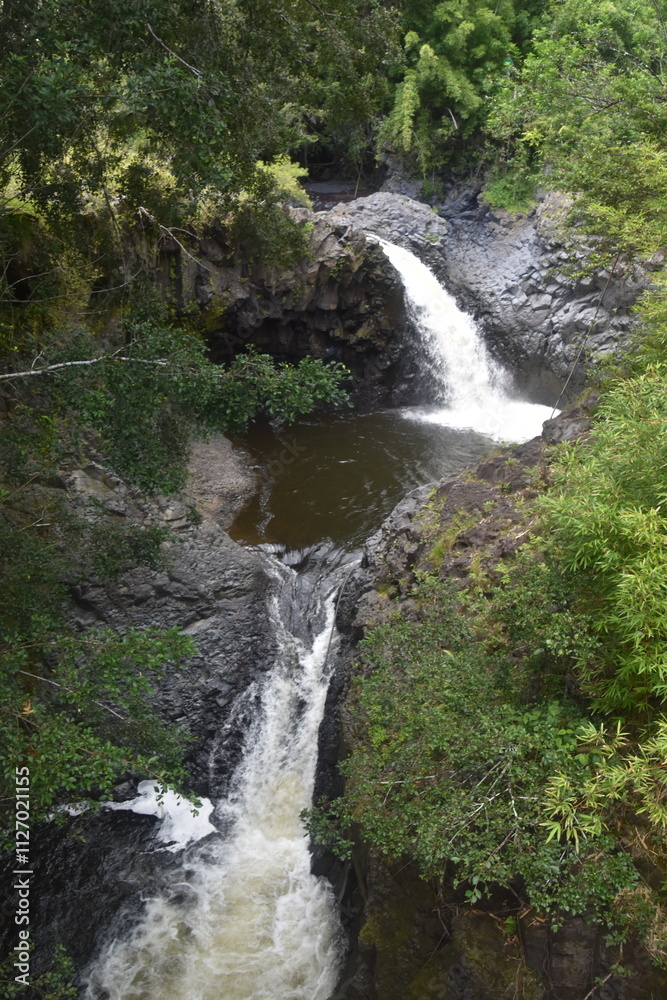 Naklejka premium The stunning big wateralls running over the black lava rocks on Maui Island in Hawaii