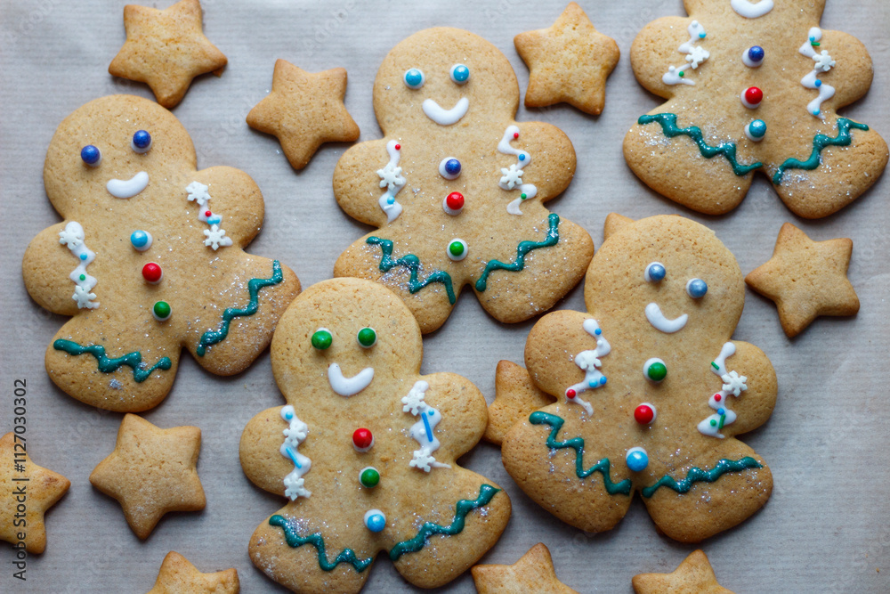 A small decorated Christmas gingerbread man surrounded by other sweets. Christmas baking A small decorated Christmas gingerbread man surrounded by other sweets. Christmas baking