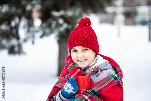 Happy child girl holding mug of hot cocoa, chocolate or tea. Children activity in winter day. Holiday vacation concept.