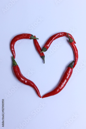 Red hot chili peppers in the shape of a heart on a white background