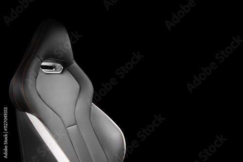 Black leather interior of the luxury modern car. Perforated black leather. Seats with stitching isolated on black background. Modern car interior details. Car inside