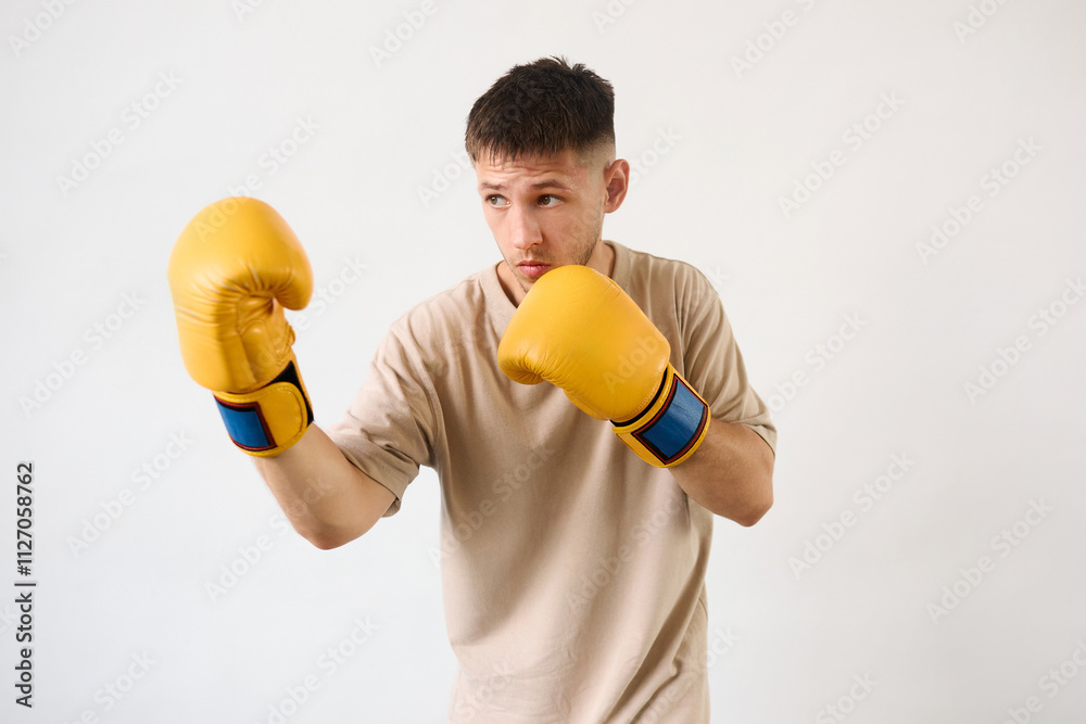 Handsome young guy shows defense technique with boxing gloves Handsome young guy shows defense technique with boxing gloves